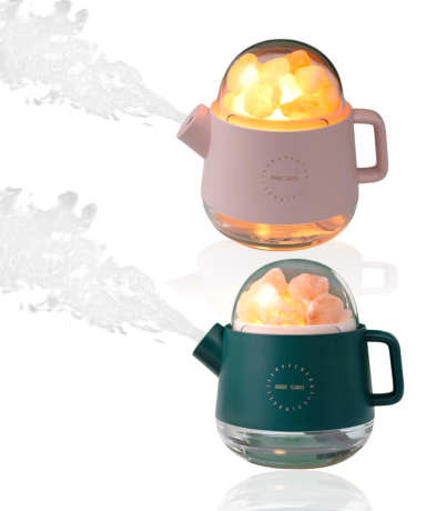 Två diffusorer för aromaterapi i rosa och grön, med ånga som strömmar ut.